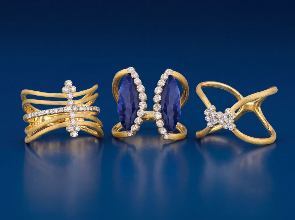 Yellow gold fashion rings including an open bypass ring with marquise blue sapphires and a criss-cross ring