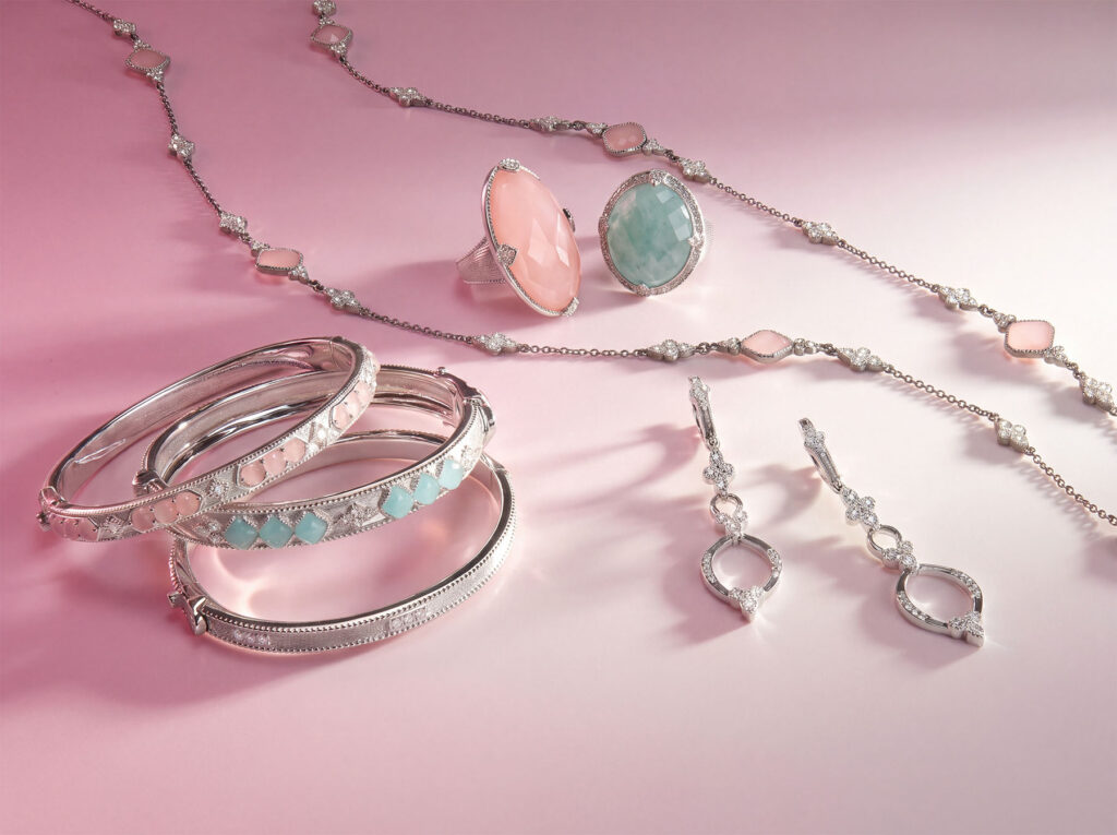 Silver jewelry suite featuring pink and green gemstone cocktail rings, a station chain necklace, and bangles