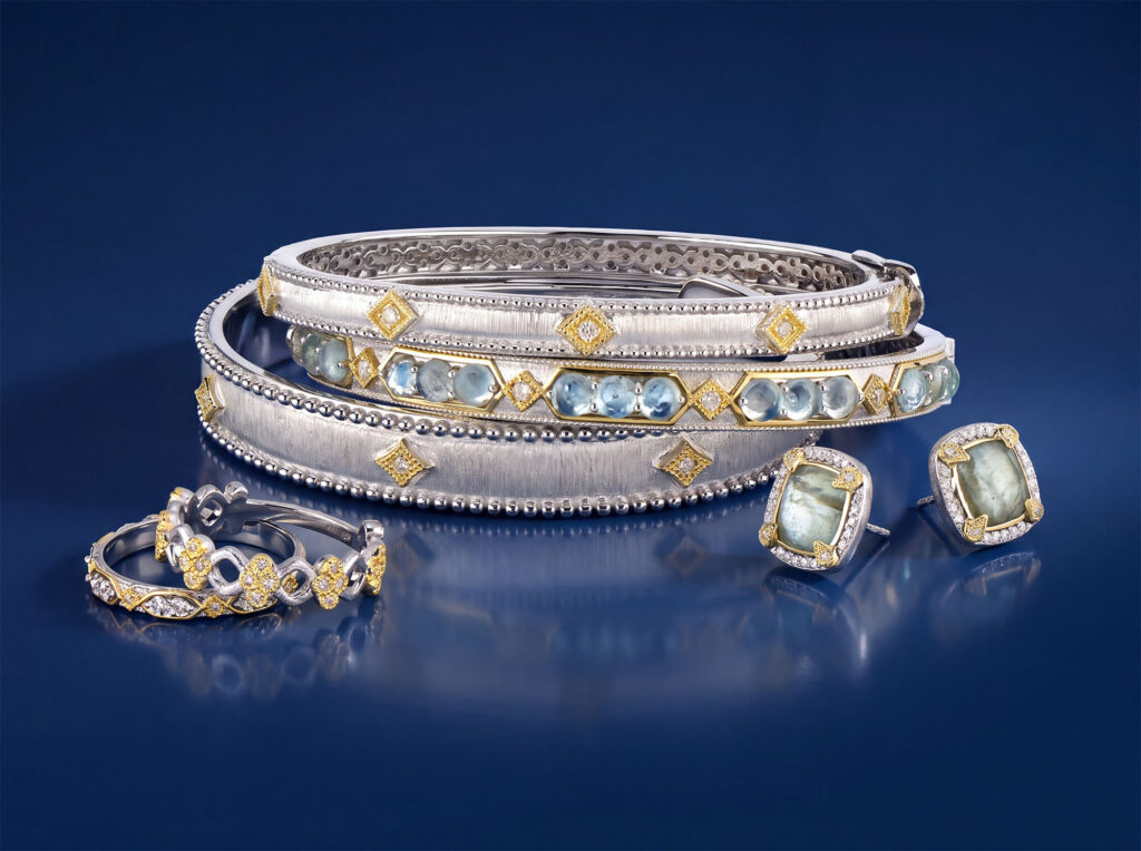 Two-tone satin silver and gold cuff bracelets with aquamarine stones, matching earrings, and diamond bands