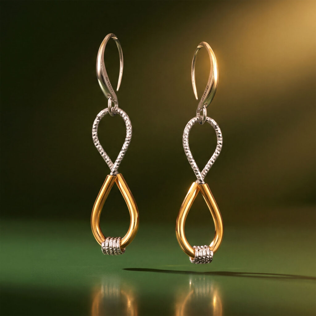 Two-tone infinity drop earrings with gold teardrops and textured sterling silver twists hanging vertically